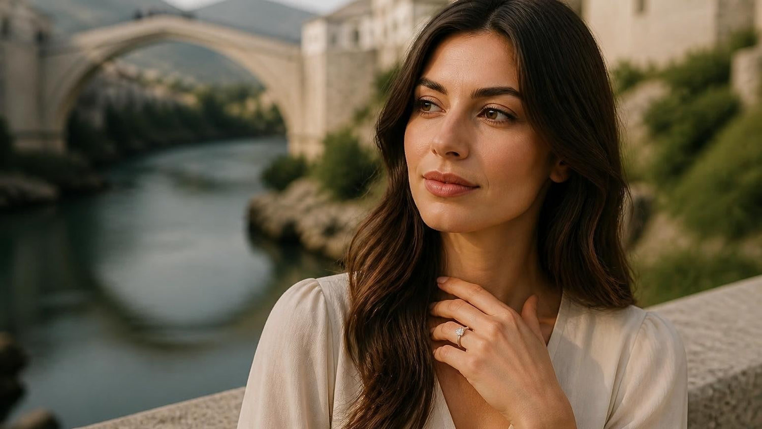 Best engagement rings in Bosnia and Herzegovina — elegant woman with Satéur Destinée Ring, Stari Most bridge behind