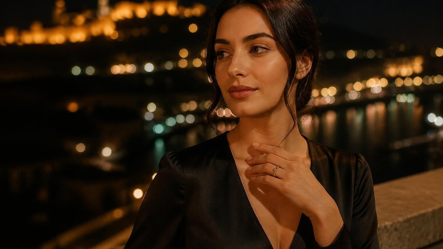 Elegant Georgian woman wearing a Satéur Destinée Ring with Narikala Fortress illuminated behind her at night