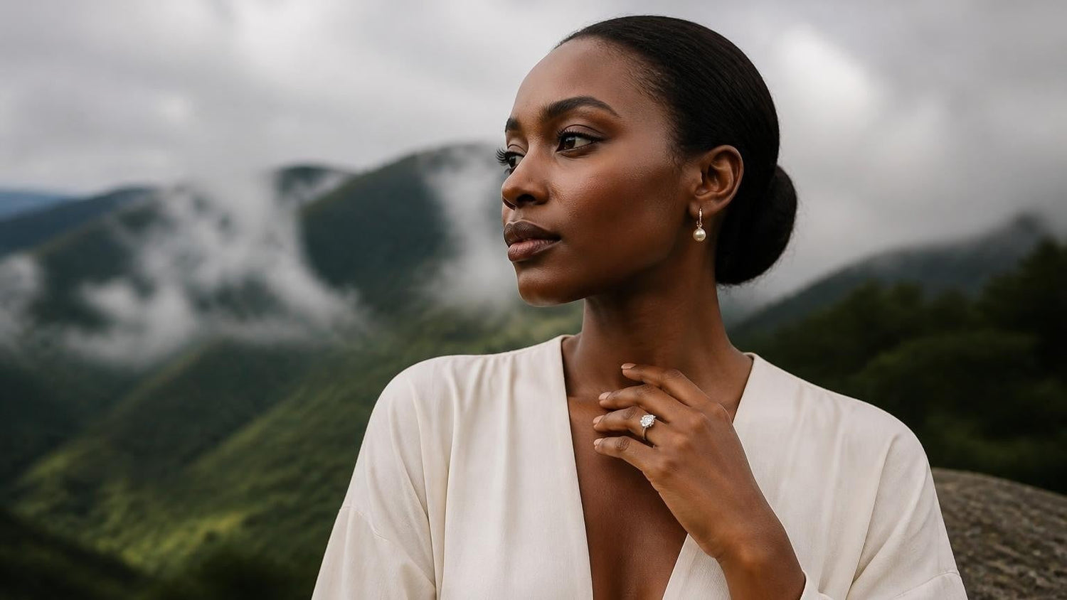 Best engagement rings in Rwanda — elegant Rwandan woman with ring, Volcanoes National Park mist-covered slopes behind