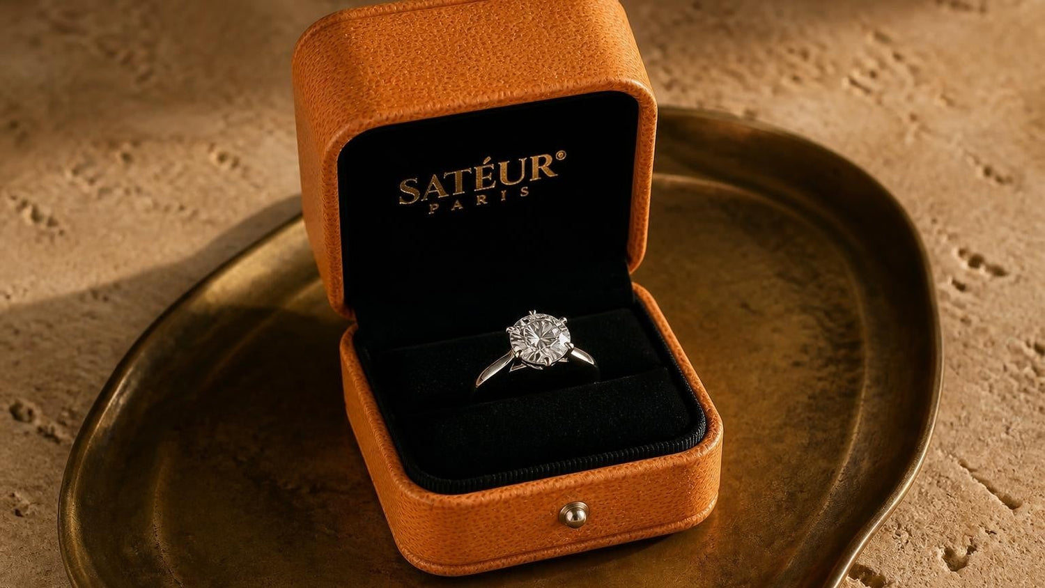 Satéur Destinée Ring™ in an open Satéur box on travertine surface — cubic zirconia vs diamond simulant comparison