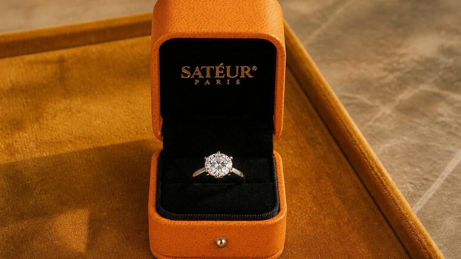 Diamond ring alternatives — open Satéur box with diamond simulant engagement ring on amber velvet