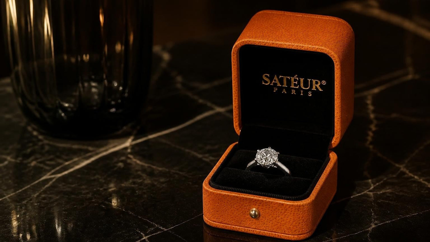 Satéur Destinée Ring beside open orange Satéur box on espresso dark marble