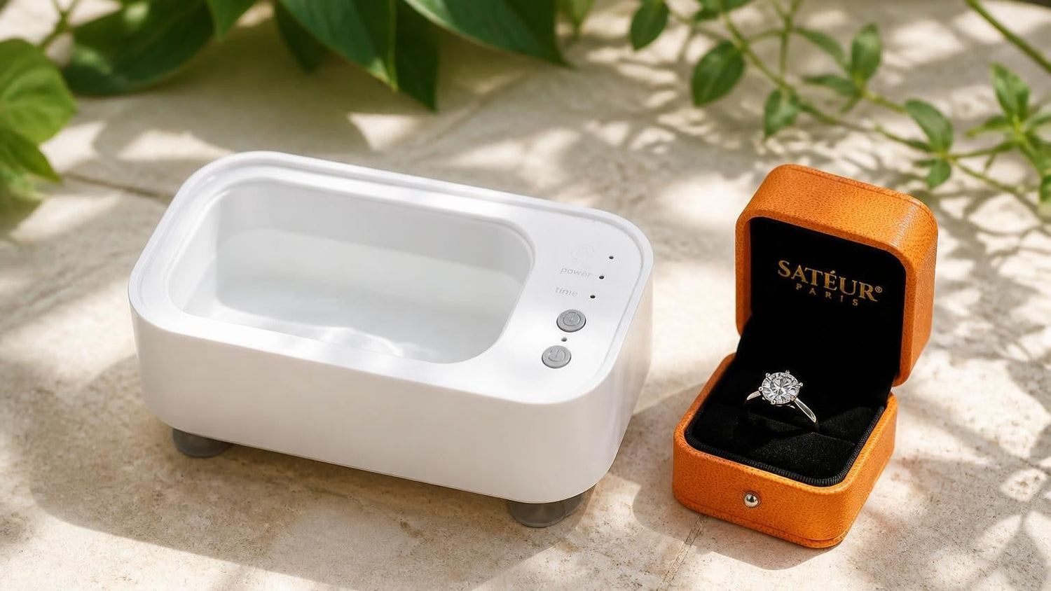 Satéur Ultrasonic Jewelry Cleaner with ring and open orange Satéur box in a sunlit conservatory