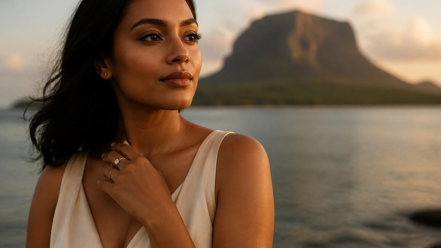 Best engagement rings in Mauritius — elegant Mauritian woman with Le Morne Brabant at sunset, solitaire ring on finger