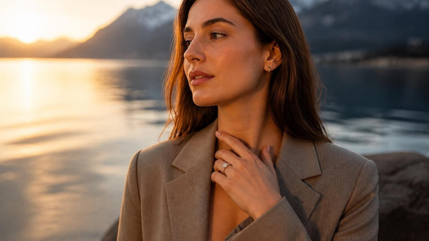 Elegant Swiss woman wearing a Satéur Destinée Ring™ at Lake Geneva at golden hour, Alps in the background
