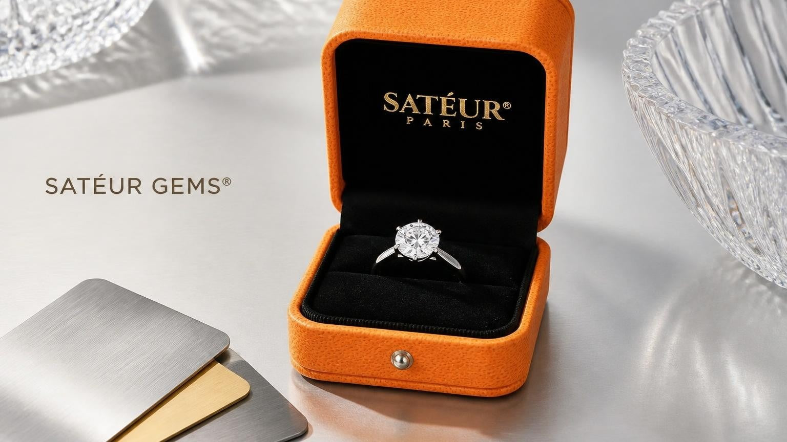 Satéur Gems® ring in open orange box with gold and silver metal swatches — best metal for engagement ring