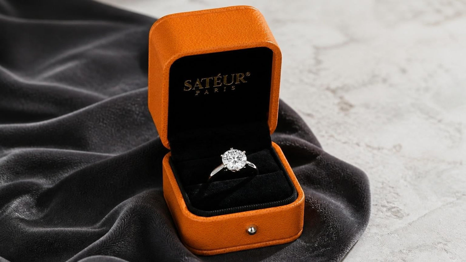 Lab-grown diamond engagement ring in open orange Satéur box with black velvet interior